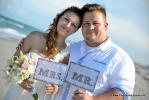 Hochzeitspaar in Delray Beach mit Mr.and Mrs. Schildern und Brautstrauss in Creme passend zum Kleid