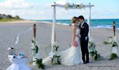 Hochzeit am menschenleeren Sandstrand von Delray mit Lanaibogen und Brautpaar