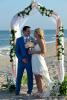 Rosenbogen mit Braut und Braeutigam am Strand von Florida