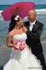 Braut mit Sonnenschirm am Strand