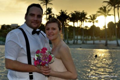 Romantische Trauung zum Sonnenuntergang mit Palmen und Meer im schoenen Florida Licht