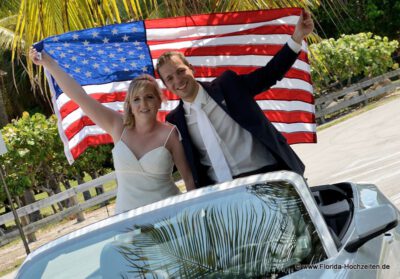 Hochzeitspaar und US Flagge im Cabriolet
