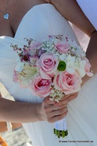 Rose&#039; farbener Brautstrauss mit wunderschoenem Hochzeitskleid