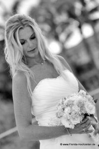 Heiraten in Florida wunderschoene Braut schaut auf Brautstrauss