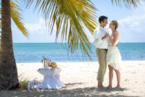 Hochzeitspaar am Strand unter Palmen