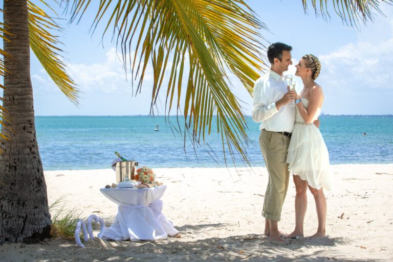 Hochzeitspaar am Strand unter Palmen