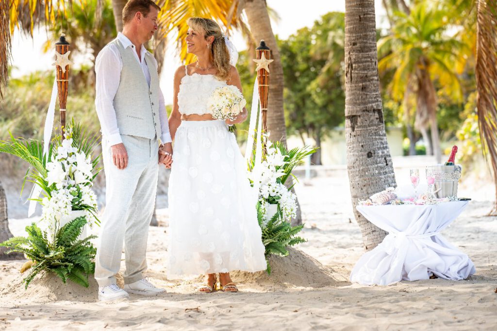 Hochzeitspaar vor der Together Forever Deko unter Palmen