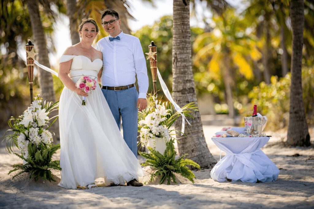 Brautpaar unter Palmen am Strand in der Simply the Best Deko